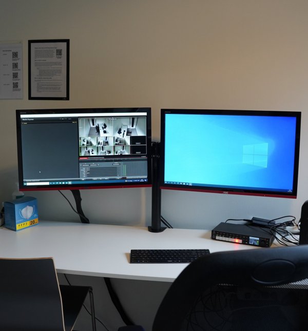 Two screens with the camara recoding the cubicles being shown.