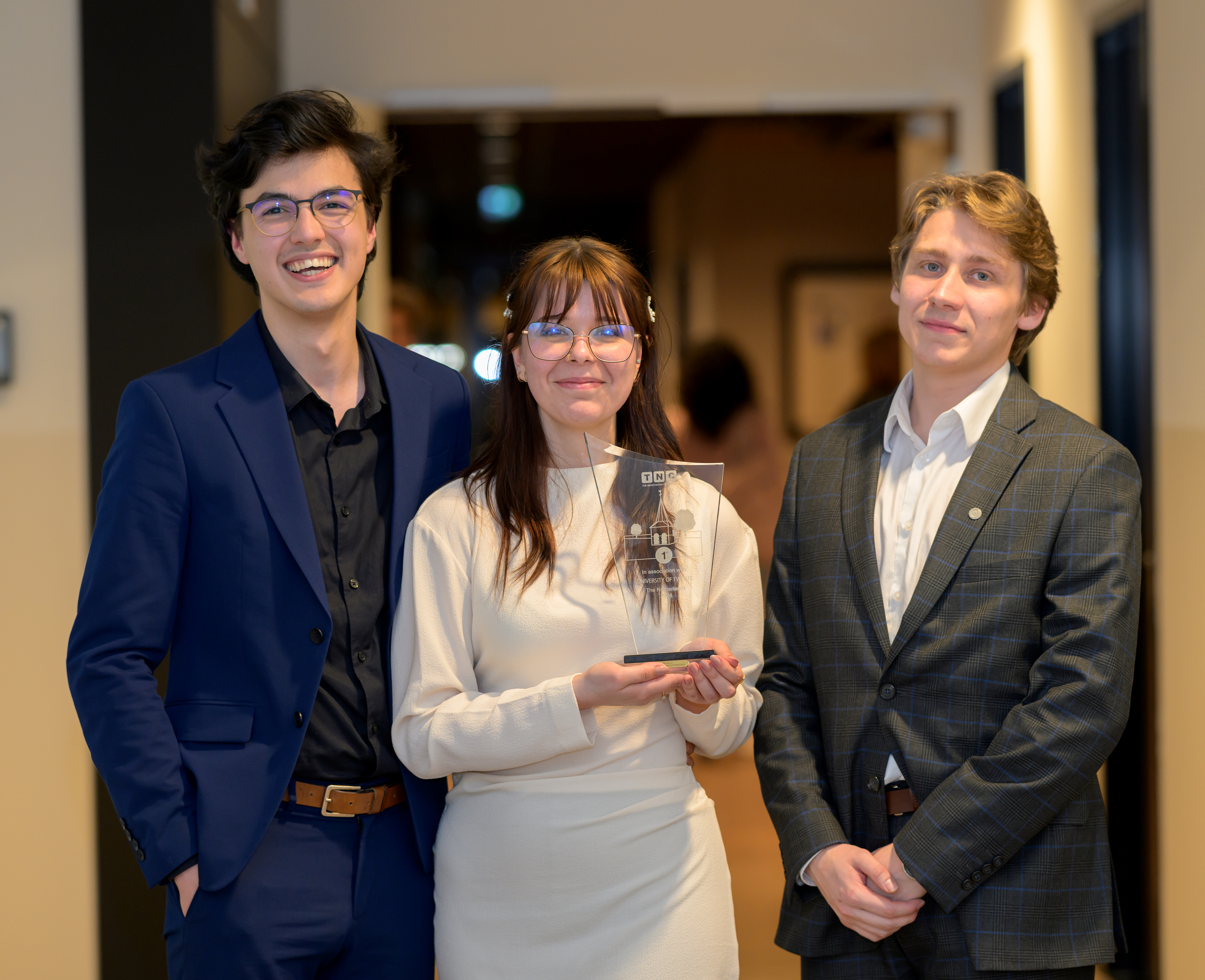 Richard, Diana en Artur lachen in de camera met hun prijs in handen.