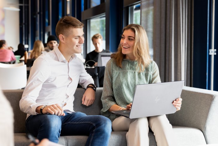 Studenten zitten achter hun laptop.