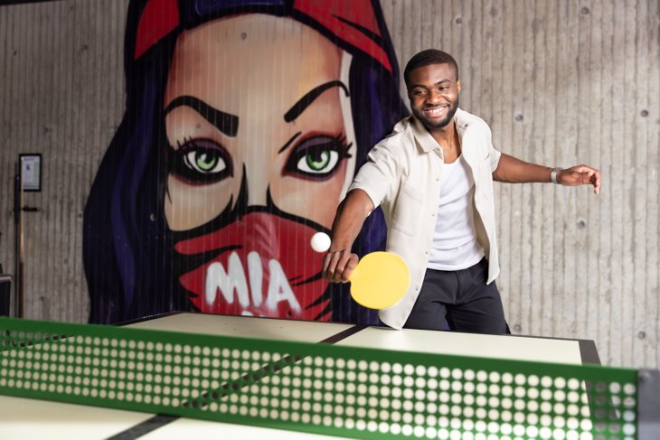A student is playing a game of ping pong.