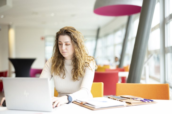 Student zittend achter haar laptop
