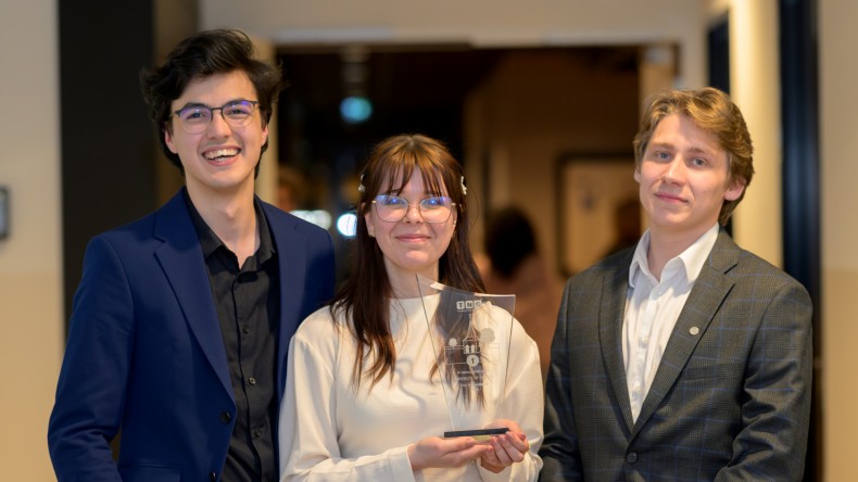 Richard, Diana en Artur lachen in de camera met hun prijs in handen.