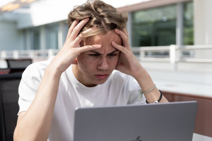 Student feeling stressed behind his laptop