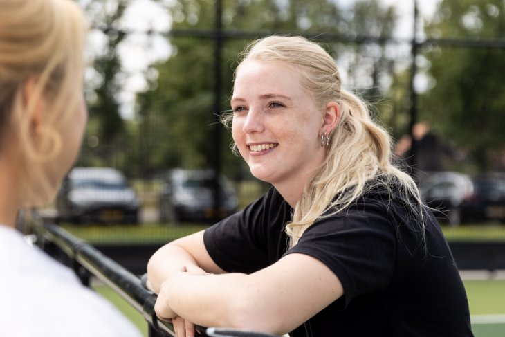 Een student praat met een andere student
