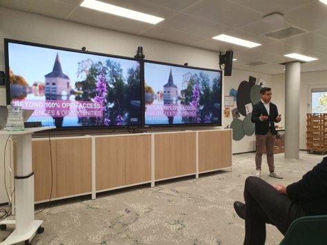 A person standing in front of a large screen

Description automatically generated