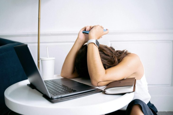 Vrouw met hoofd op tafel door stress