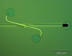 Figure 1: microchannel made by sacrificial KOH-etching of poly-Si, crossing a channel made by anisotropic KOH-etching of the mono-crystalline substrate. a) Overiew