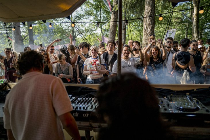 People dancing in front of a dj booth