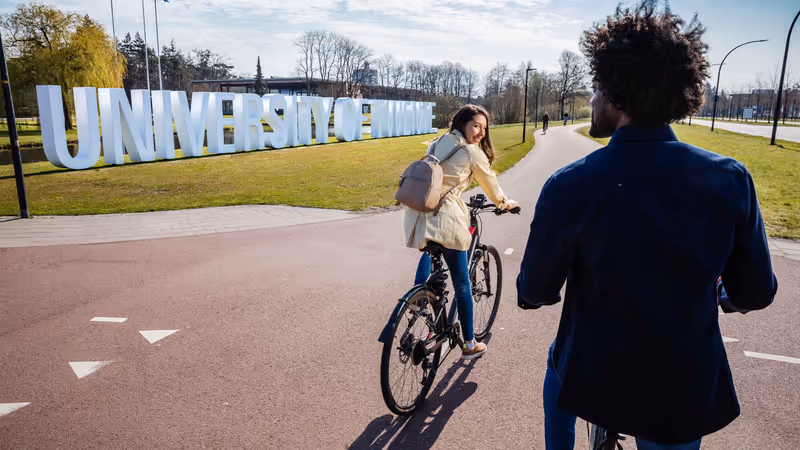 students on their bike towards the university of twente
