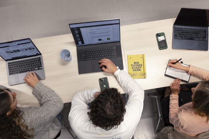 An aerial photo of three students working on their laptops.