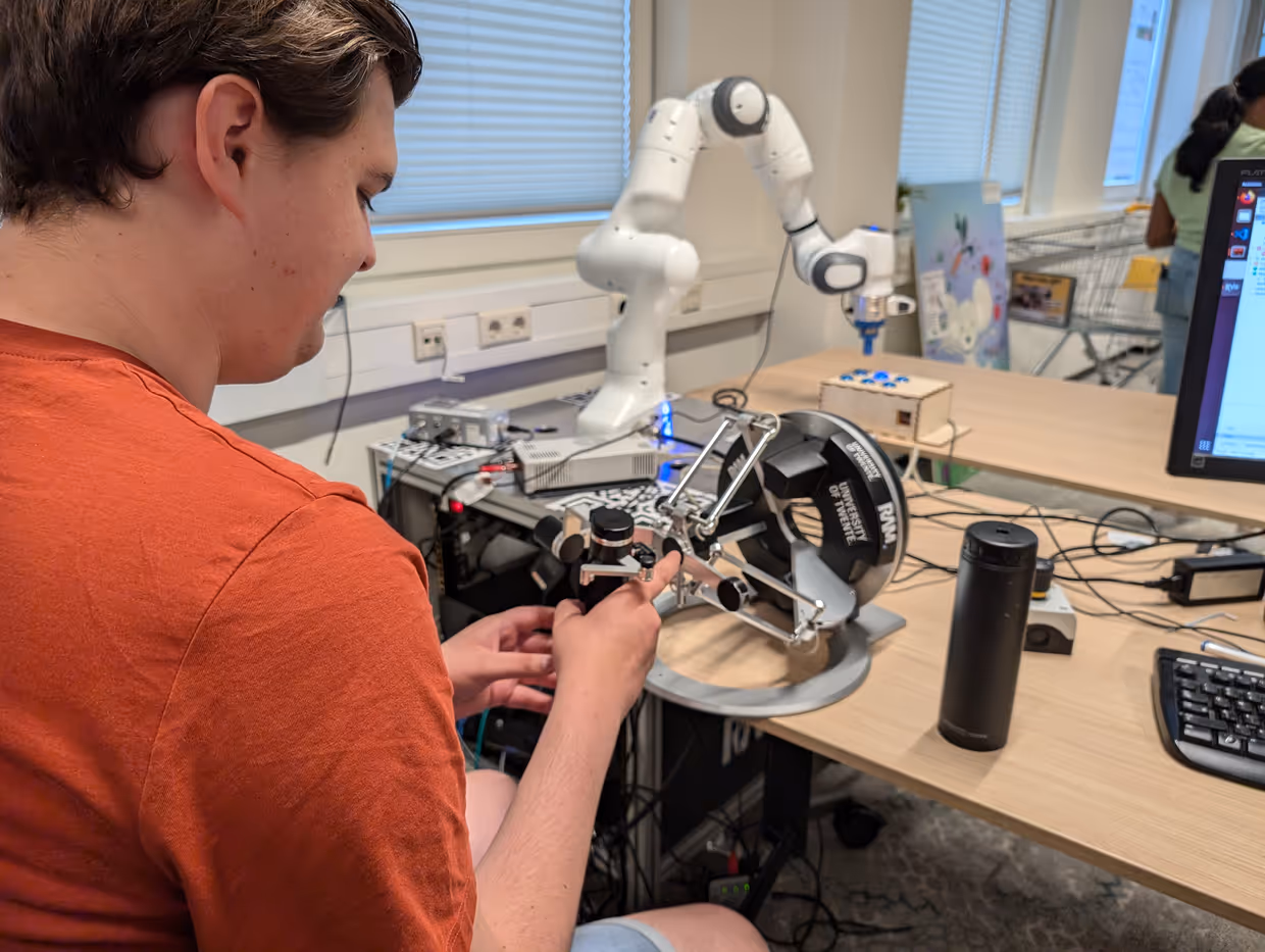 a person remote controlling a robot arm
