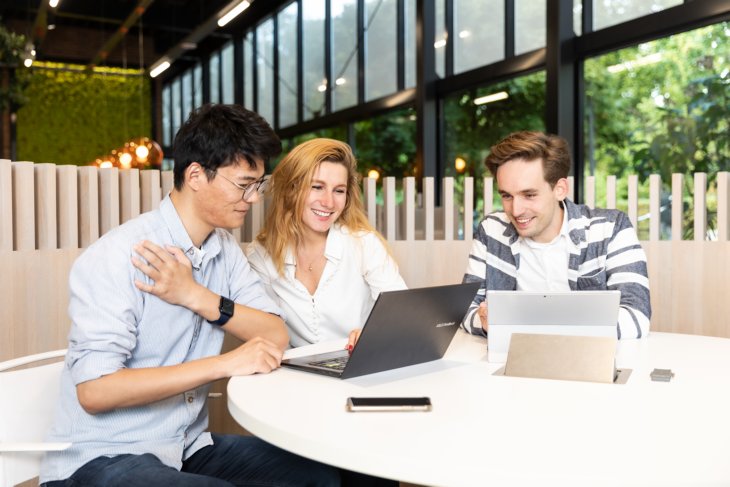Drie studenten werken samen aan een project.