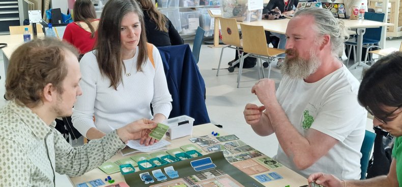 A group of players play the Sudsbury 2.0 board game at the Enschede library.