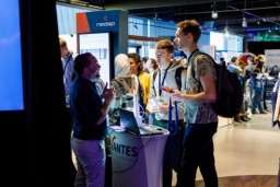 Studenten van de Universiteit Twente op een Career Fair van Bedrijvendagen Twente. Ze praten met een standhouder.