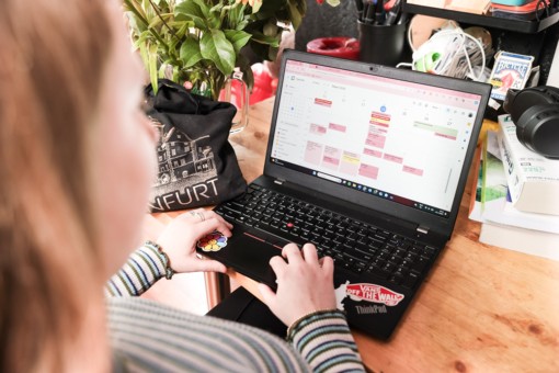 A student of the University of Twente sits behind her laptop, looking at her calendar to make a study plan.