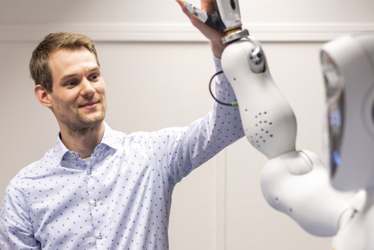 Employee gives a high-five to a robot