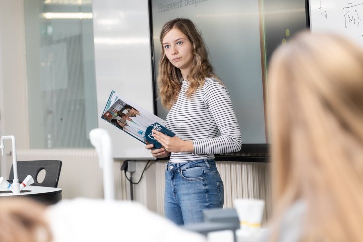 Student van de Universiteit Twente geeft bijles aan groep leerlingen als bijbaan