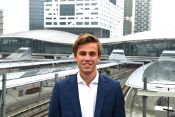 Construction Management & Engineering alumnus Robin from the University of Twente smiles into the camera, standing in front of a station.