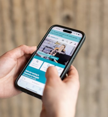 Student kijkend naar kamerzoeksite op telefoon