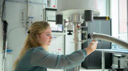 Student is adjusting a setup and taking measurements in a laboratory for quantum research.