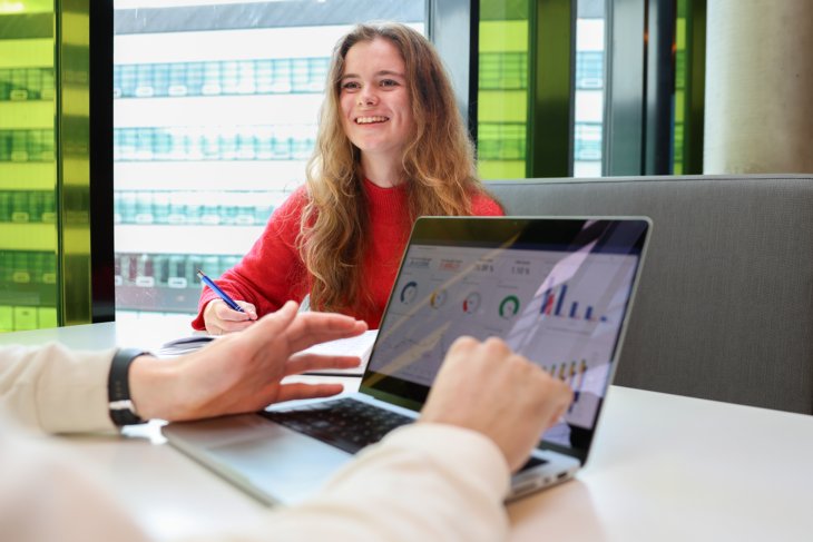Data science studenten werken samen aan een project. Op het laptopscherm zijn allerlei grafieken te zien.
