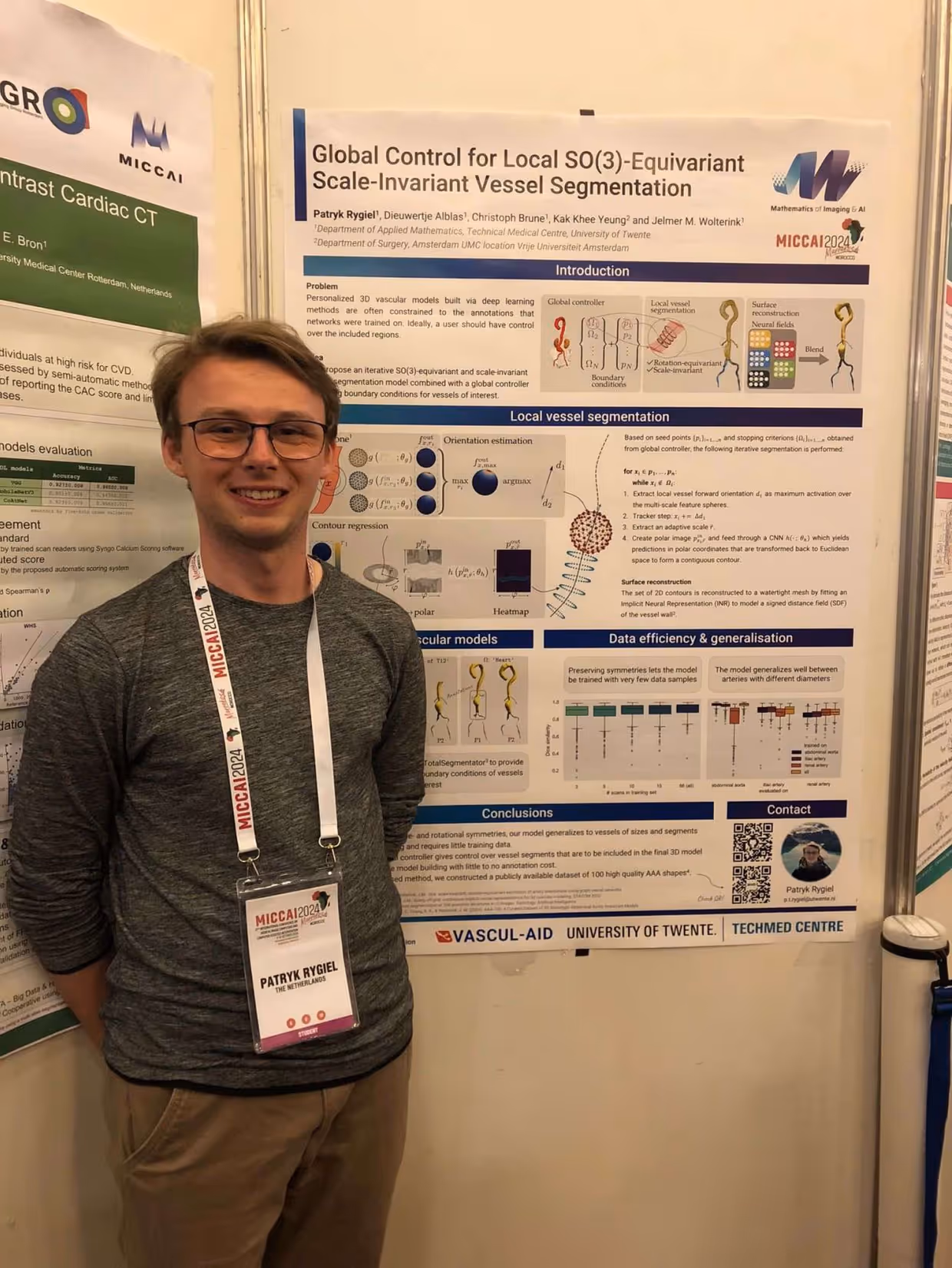 Patryk Rygiel in front of winning poster