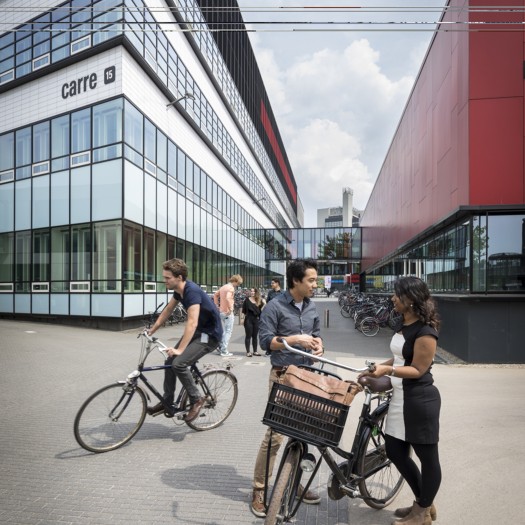 Studenten lachen en praten op de campus.