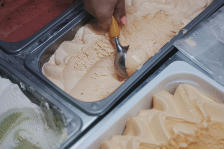 A student scooping ice cream on their summer job.