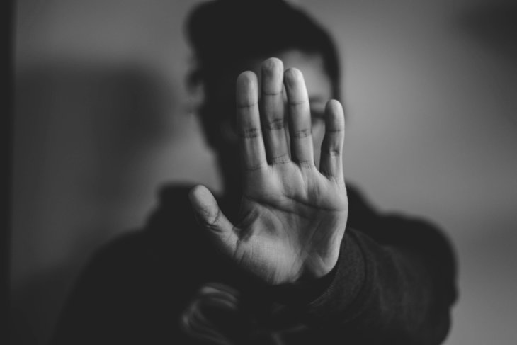 Een vrouw maakt een 'stop' teken met haar hand.