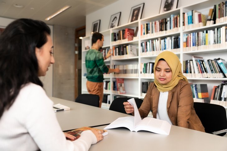 Two students studying in the library together.