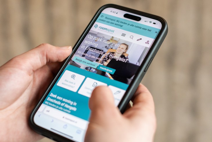 Student kijkend naar kamerzoeksite op telefoon