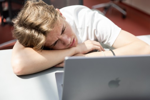 Student with frustrated expression behind his laptop