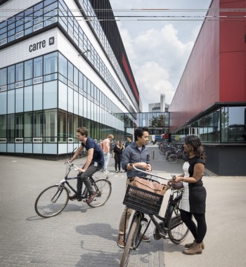 Students talking and biking on the University of Twente campus