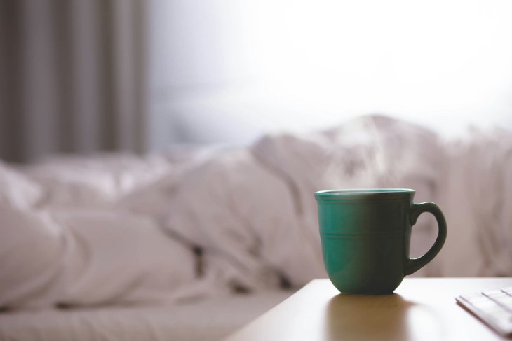 Een kop koffie op een nachtkastje.