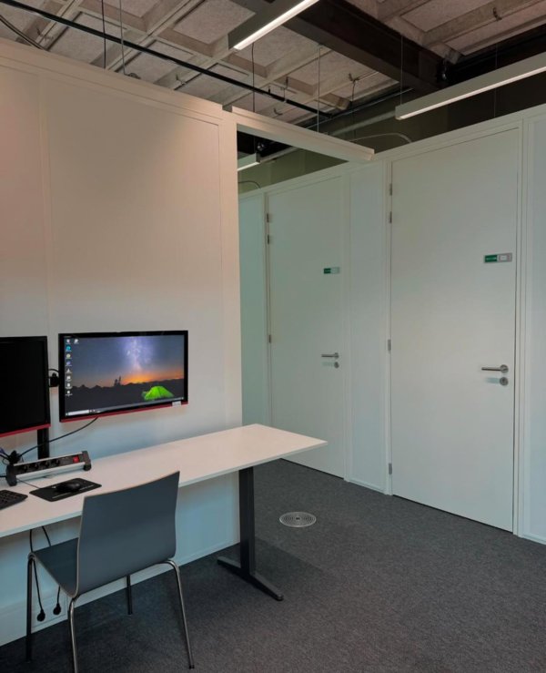 Two screens with the camara recoding the cubicles being shown.