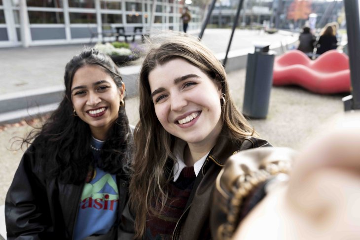 Two girls taking a selfie with a phone